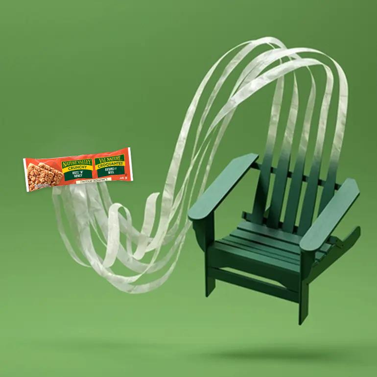 A Nature Valley Crunchy Oats 'N' Honey Bar with plastic ribbons coming out of the package and flowing into an image of a plastic chair
