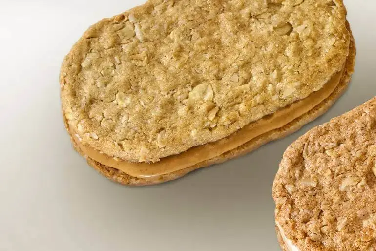 Nature Valley CA two biscuit sandwiches one filled with peanut butter and the other with cream.