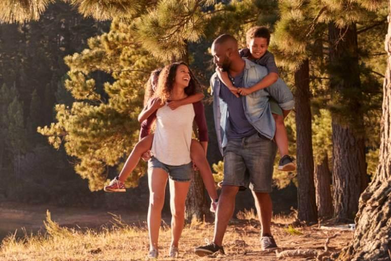A serene lake setting with a family standing together, surrounded by tall trees